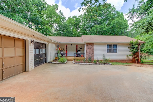 ranch-style home with a porch and a garage