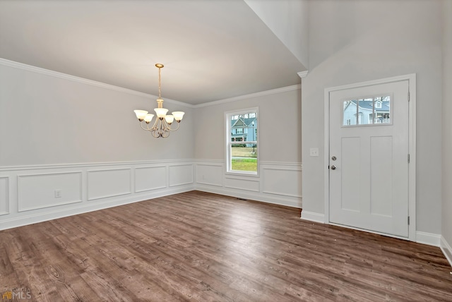 entrance foyer with crown molding, dark wood-type flooring, and a chandelier