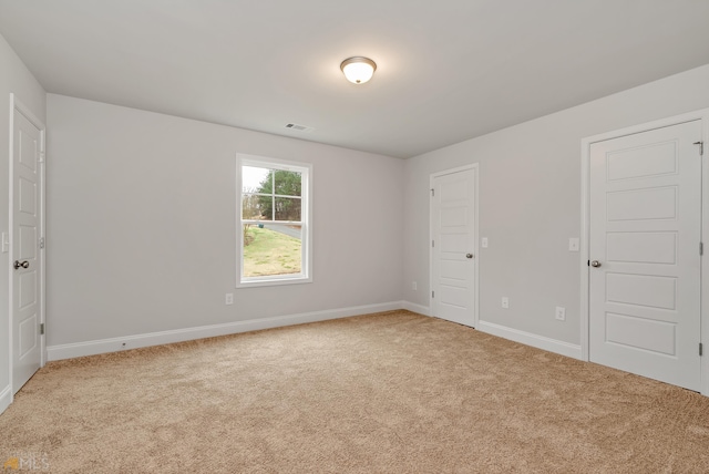 spare room featuring light carpet