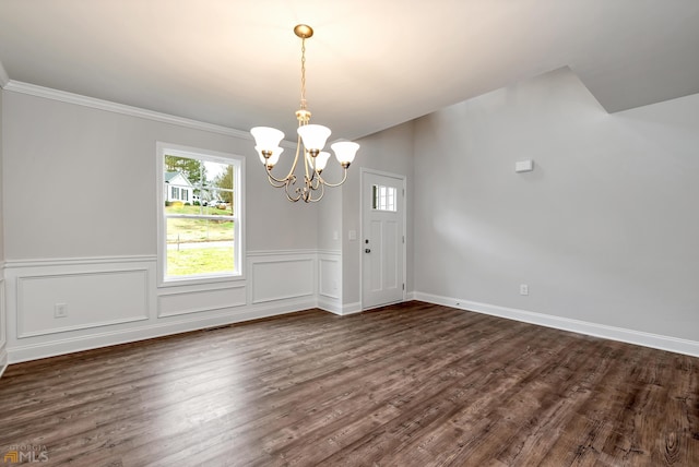 unfurnished dining area with dark hardwood / wood-style floors, crown molding, and a chandelier