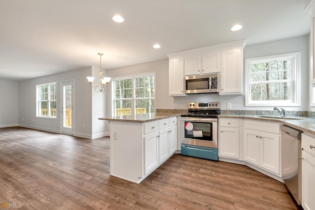 kitchen with white cabinets, stainless steel appliances, and a wealth of natural light