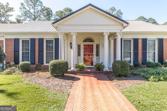 neoclassical / greek revival house with a front yard and covered porch