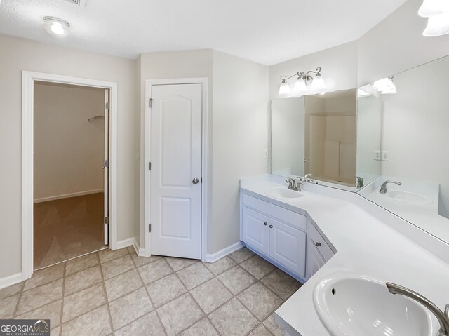 bathroom featuring vanity, a textured ceiling, and tile patterned flooring