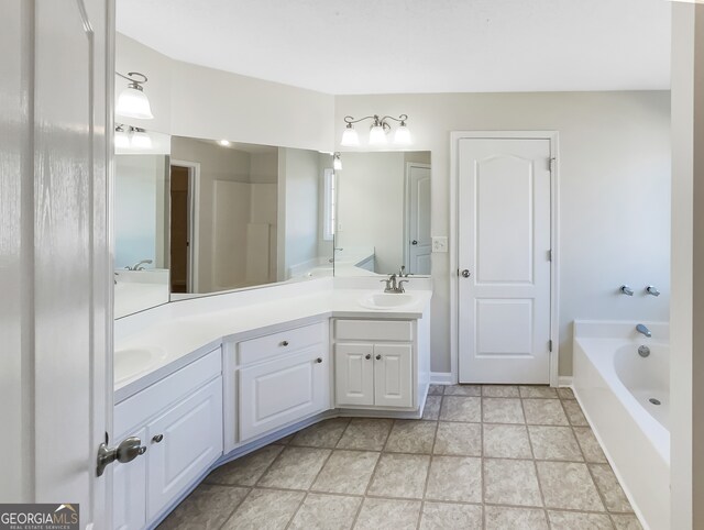 bathroom featuring vanity, a tub to relax in, and tile patterned flooring