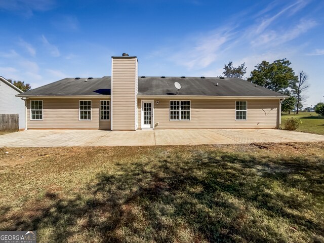 rear view of house featuring a patio and a lawn