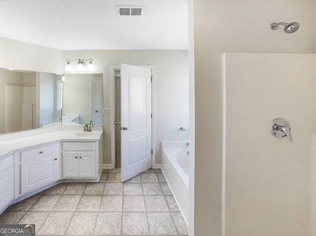 bathroom with vanity, a bathtub, and tile patterned flooring