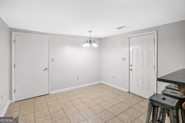 interior space with a chandelier and a textured ceiling