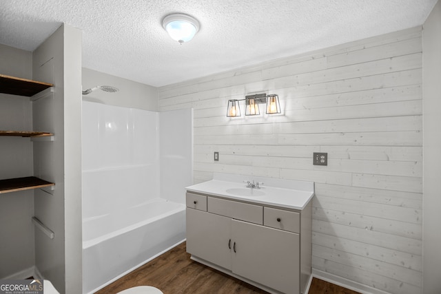 bathroom featuring vanity, hardwood / wood-style floors, shower / tub combination, and a textured ceiling