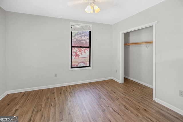 unfurnished bedroom with a closet and hardwood / wood-style flooring