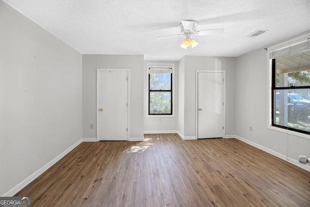 spare room featuring ceiling fan, wood-type flooring, and a textured ceiling