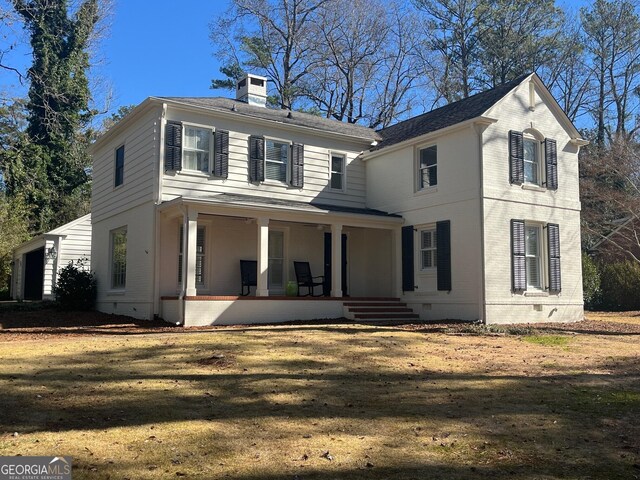 view of front of property featuring covered porch and a front lawn