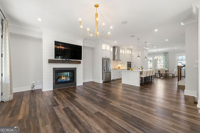 unfurnished living room featuring ornamental molding, a large fireplace, and dark hardwood / wood-style flooring