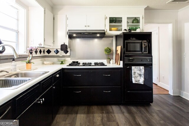 5605 Ga Highway 121, Blackshear, GA 31516 - kitchen with oven, under cabinet range hood, a sink, gas cooktop, and dark cabinetry