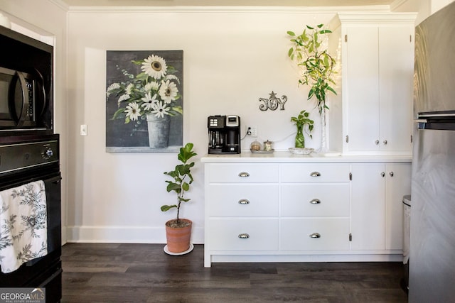 5605 Ga Highway 121, Blackshear, GA 31516 - detailed view of black appliances, baseboards, dark wood-type flooring, light countertops, and white cabinetry
