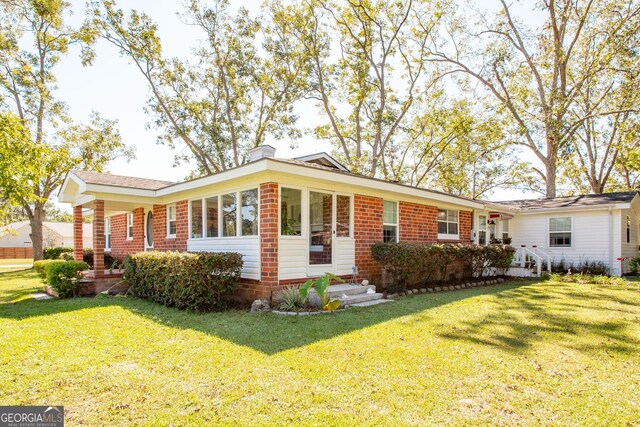 5605 Ga Highway 121, Blackshear, GA 31516 - ranch-style home with brick siding, a front yard, and a chimney