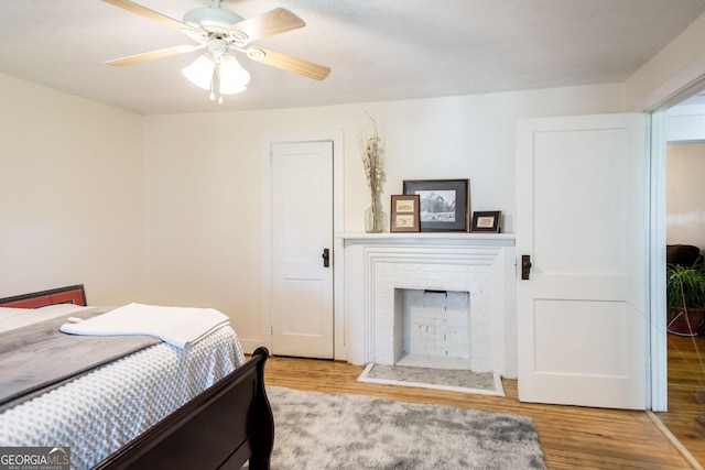 5605 Ga Highway 121, Blackshear, GA 31516 - bedroom with wood finished floors, a brick fireplace, and ceiling fan