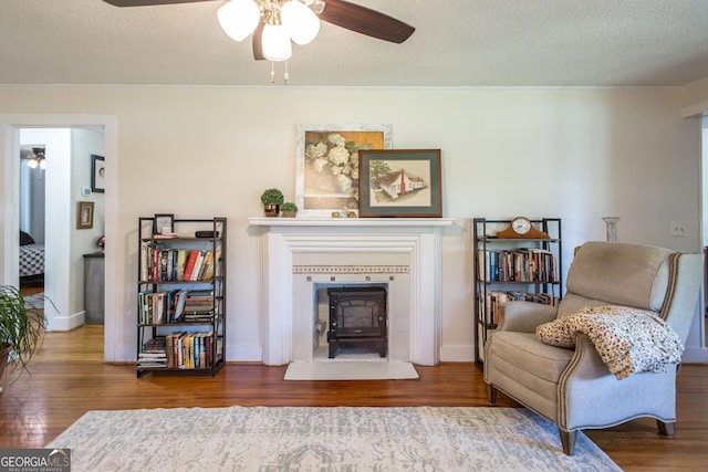 5605 Ga Highway 121, Blackshear, GA 31516 - sitting room with a ceiling fan, wood finished floors, ornamental molding, a fireplace with flush hearth, and a textured ceiling