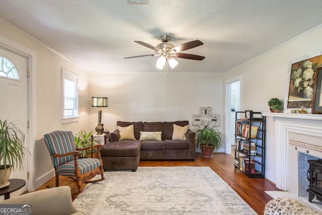 5605 Ga Highway 121, Blackshear, GA 31516 - living area with dark wood finished floors, crown molding, a ceiling fan, a textured ceiling, and a fireplace with flush hearth