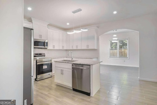 kitchen featuring light stone counters, appliances with stainless steel finishes, sink, and white cabinets