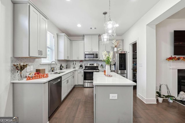 kitchen with a center island, stainless steel appliances, sink, and dark hardwood / wood-style flooring