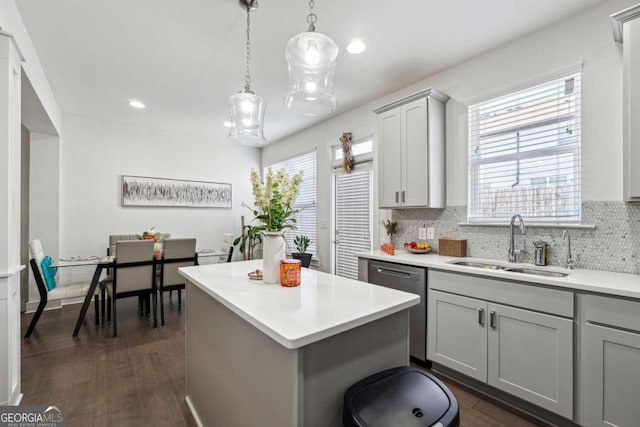 kitchen with gray cabinetry, sink, stainless steel dishwasher, and dark hardwood / wood-style floors