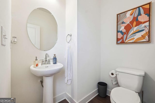 bathroom featuring toilet and wood-type flooring