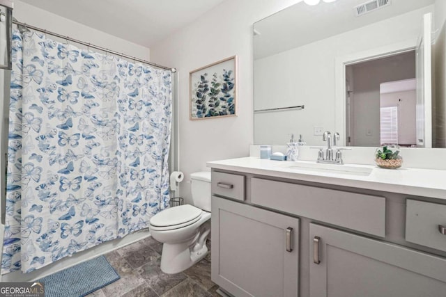 bathroom with vanity, a shower with shower curtain, and toilet