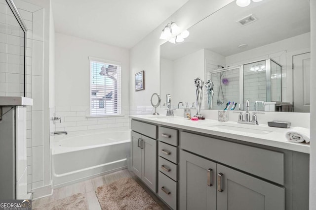 bathroom featuring vanity, separate shower and tub, and hardwood / wood-style floors