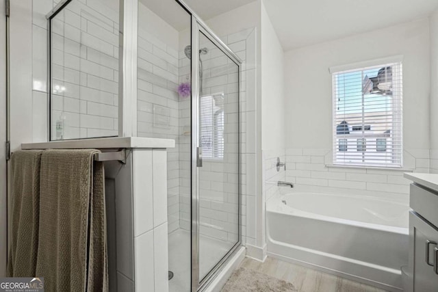 bathroom with vanity, shower with separate bathtub, and hardwood / wood-style floors