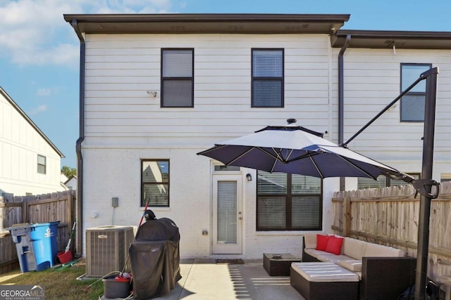 back of property with central air condition unit, a patio, and an outdoor hangout area