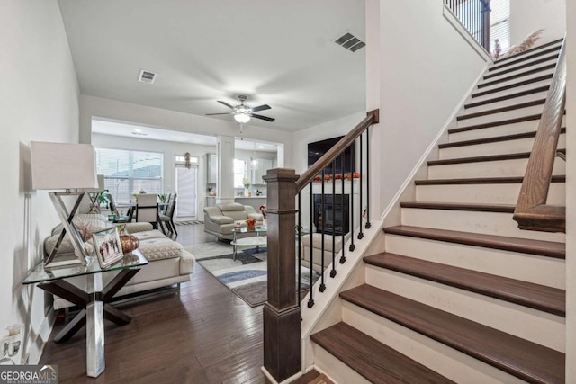 stairway with hardwood / wood-style flooring and ceiling fan