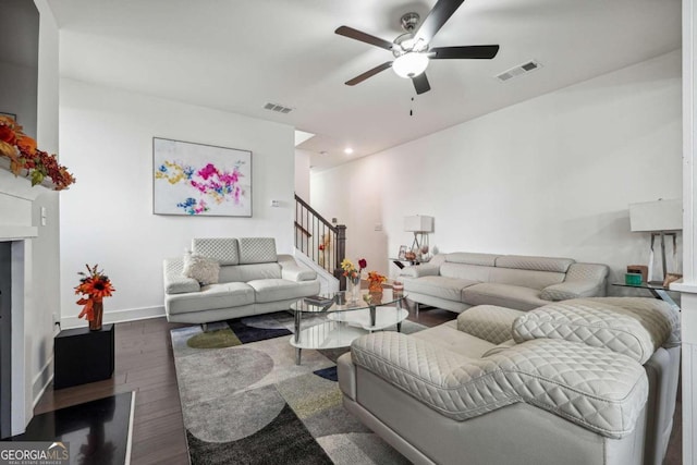 living room featuring dark wood-type flooring and ceiling fan