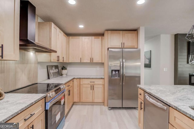 kitchen featuring light stone countertops, stainless steel appliances, wall chimney exhaust hood, and light brown cabinets