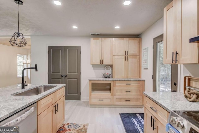 kitchen with light brown cabinets, sink, pendant lighting, appliances with stainless steel finishes, and light hardwood / wood-style floors