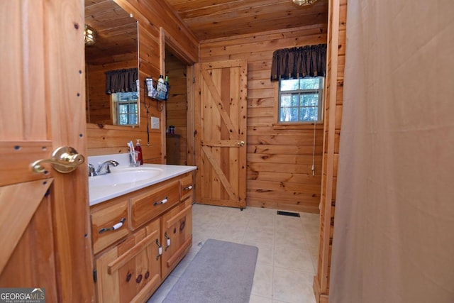 bathroom featuring vanity, wood ceiling, wood walls, and tile patterned floors