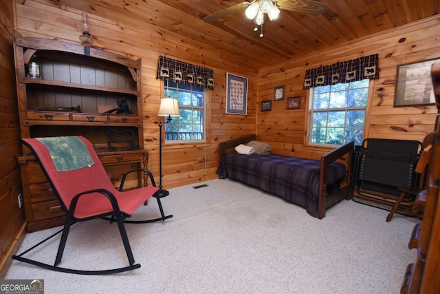 bedroom featuring light carpet, wooden walls, and wooden ceiling