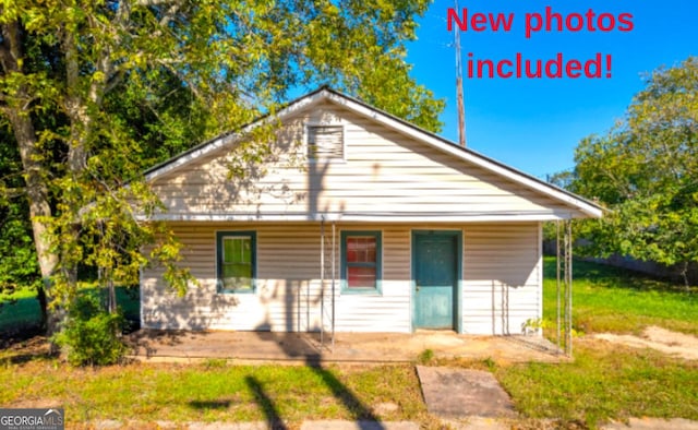 back of property with a porch and a lawn