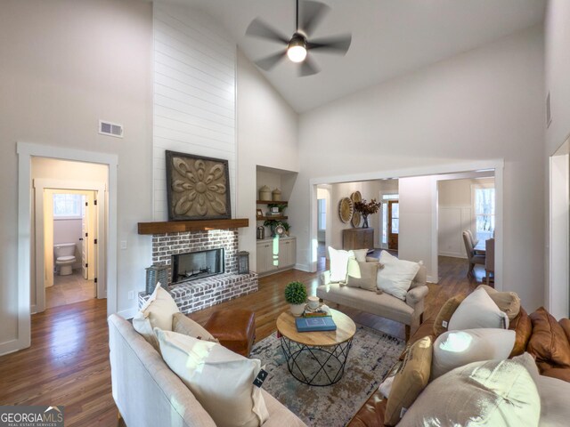 unfurnished living room featuring high vaulted ceiling, wood-type flooring, and a fireplace