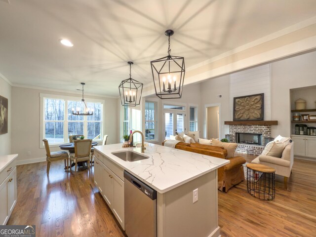 kitchen featuring wood-type flooring, stainless steel appliances, pendant lighting, sink, and a kitchen island with sink