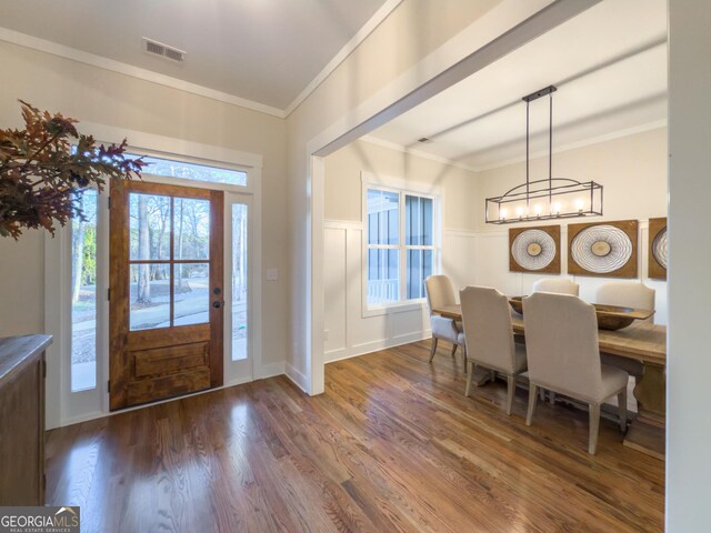 entryway with hardwood / wood-style floors, a notable chandelier, and crown molding