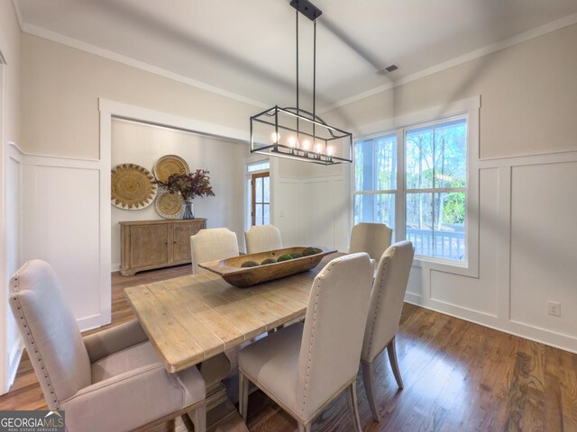 unfurnished dining area with dark wood-type flooring, an inviting chandelier, french doors, and ornamental molding