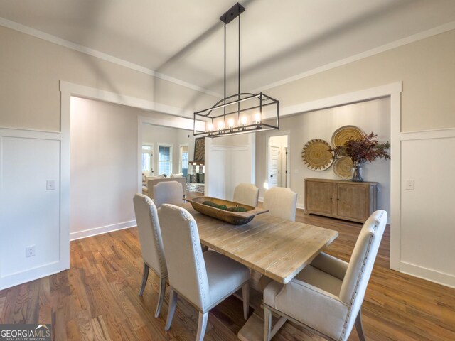 entryway featuring dark wood-type flooring, plenty of natural light, an inviting chandelier, and crown molding