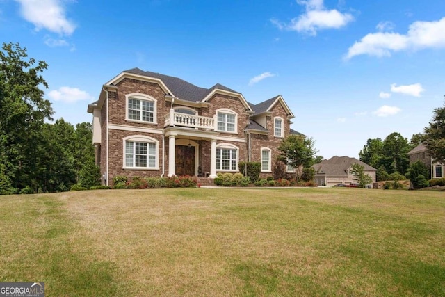 view of front of property featuring a balcony and a front yard