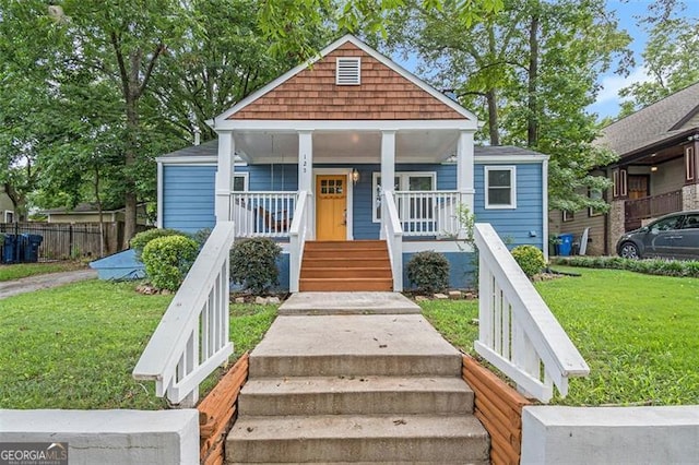 bungalow with a porch and a front lawn