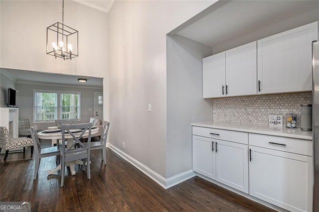 dining area with an inviting chandelier, dark wood-type flooring, and crown molding