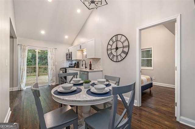 dining space with a notable chandelier, high vaulted ceiling, and dark hardwood / wood-style floors