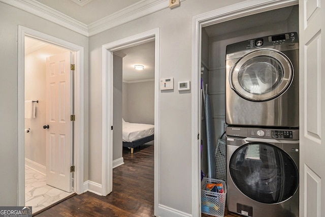 washroom with ornamental molding, stacked washing maching and dryer, and dark wood-type flooring