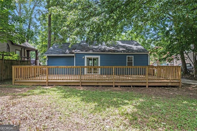 rear view of house featuring a yard and a deck