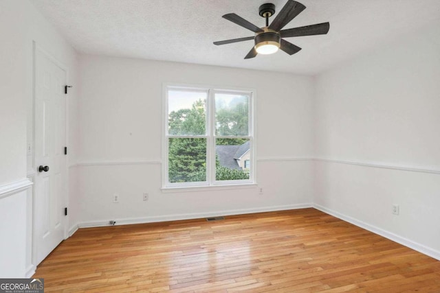 empty room featuring ceiling fan, a textured ceiling, and light hardwood / wood-style flooring