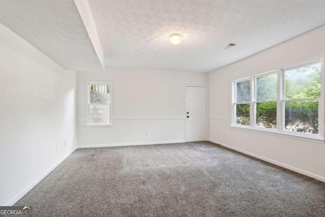 spare room with a textured ceiling and carpet flooring